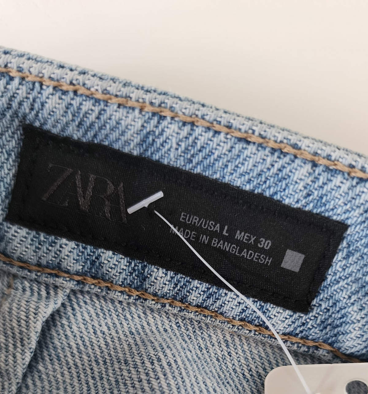 Style Reset ZARA light wash denim skort label showing size L and made in Bangladesh tag