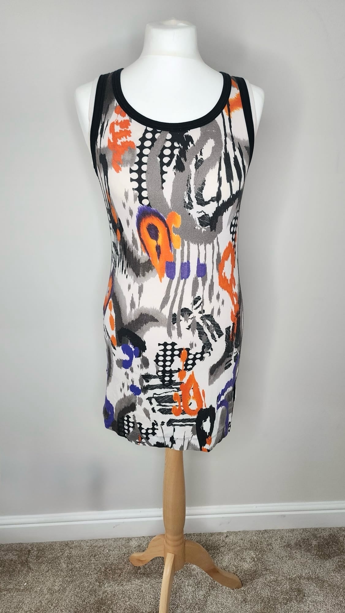 Style Reset sleeveless mini dress featuring a vibrant abstract print in orange, purple, black, and white on a mannequin
