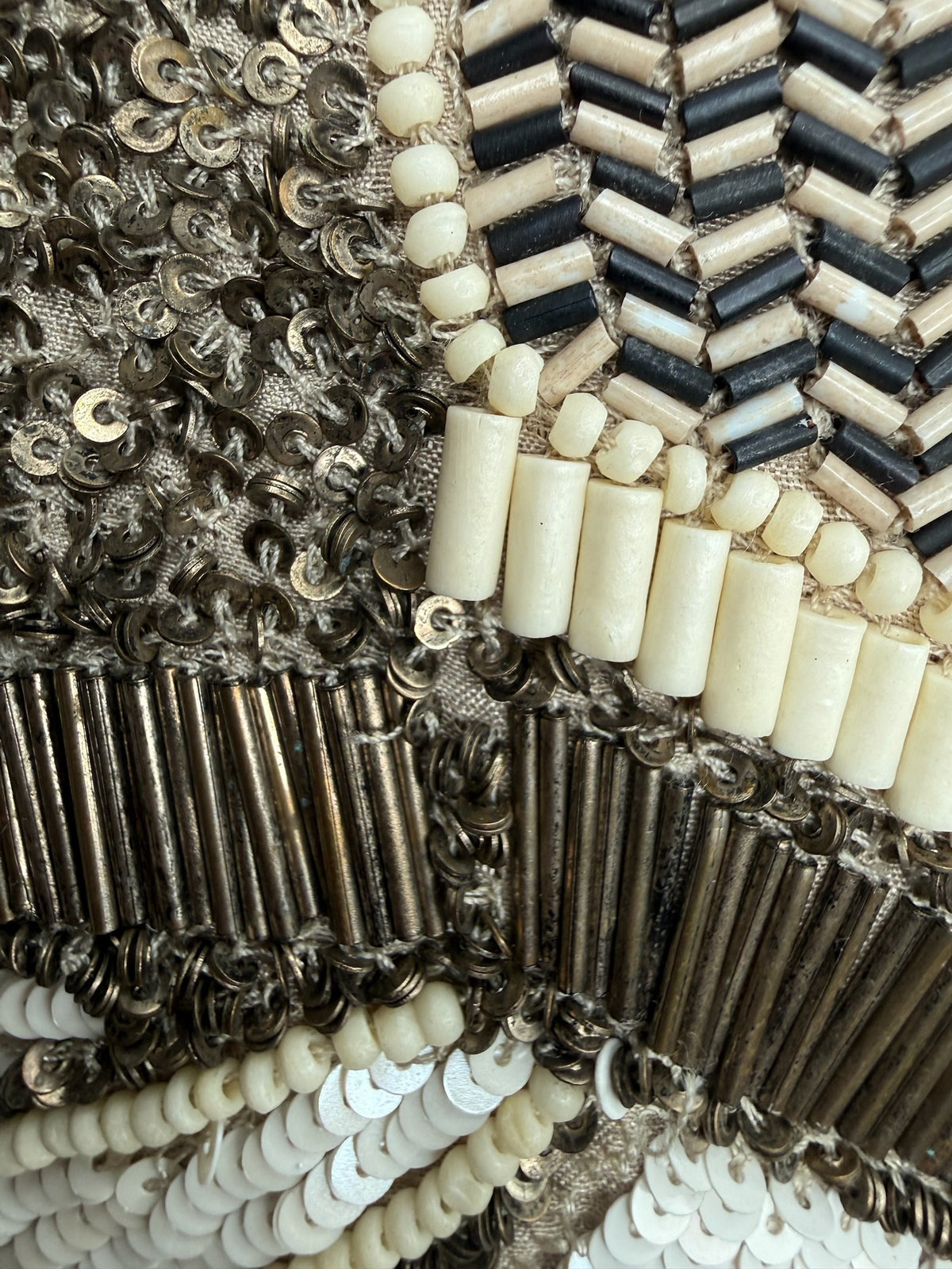 Close-up of Style Reset AllSaints embellished mini skirt featuring intricate black, cream, and bronze beadwork.