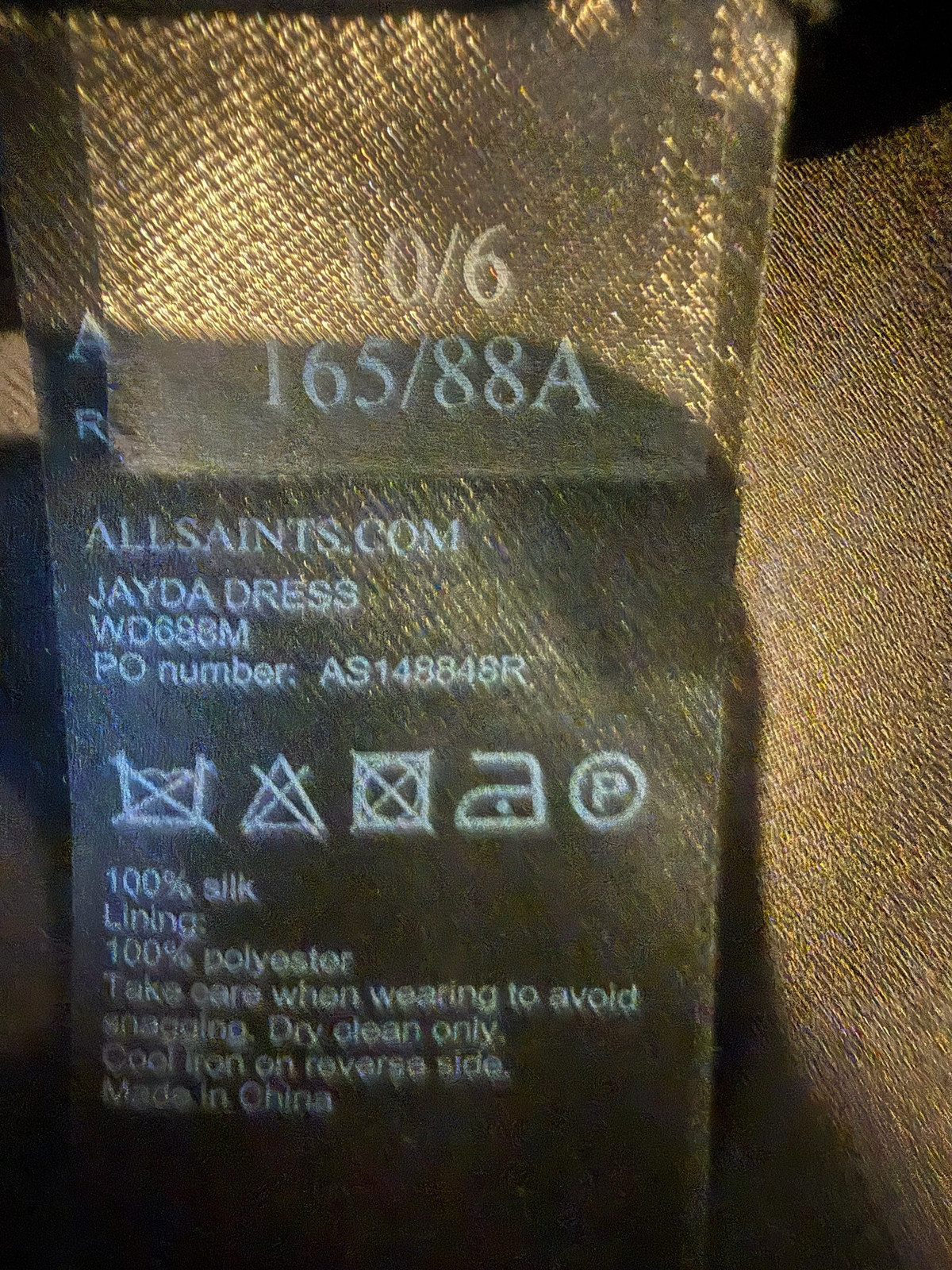 Style Reset AllSaints Jayda dress garment care label showing 100% silk material and polyester lining details