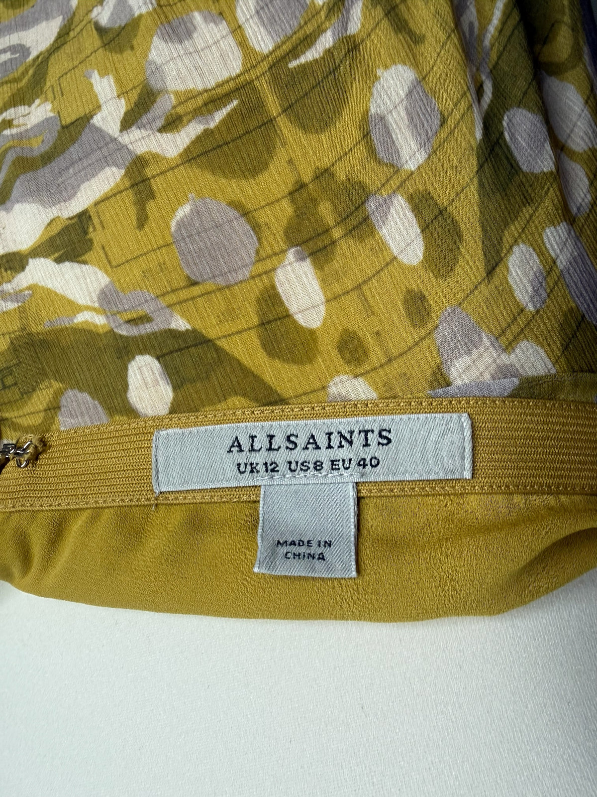 Style Reset AllSaints high-low maxi skirt label showing olive, mustard, and grey abstract print on fluid fabric