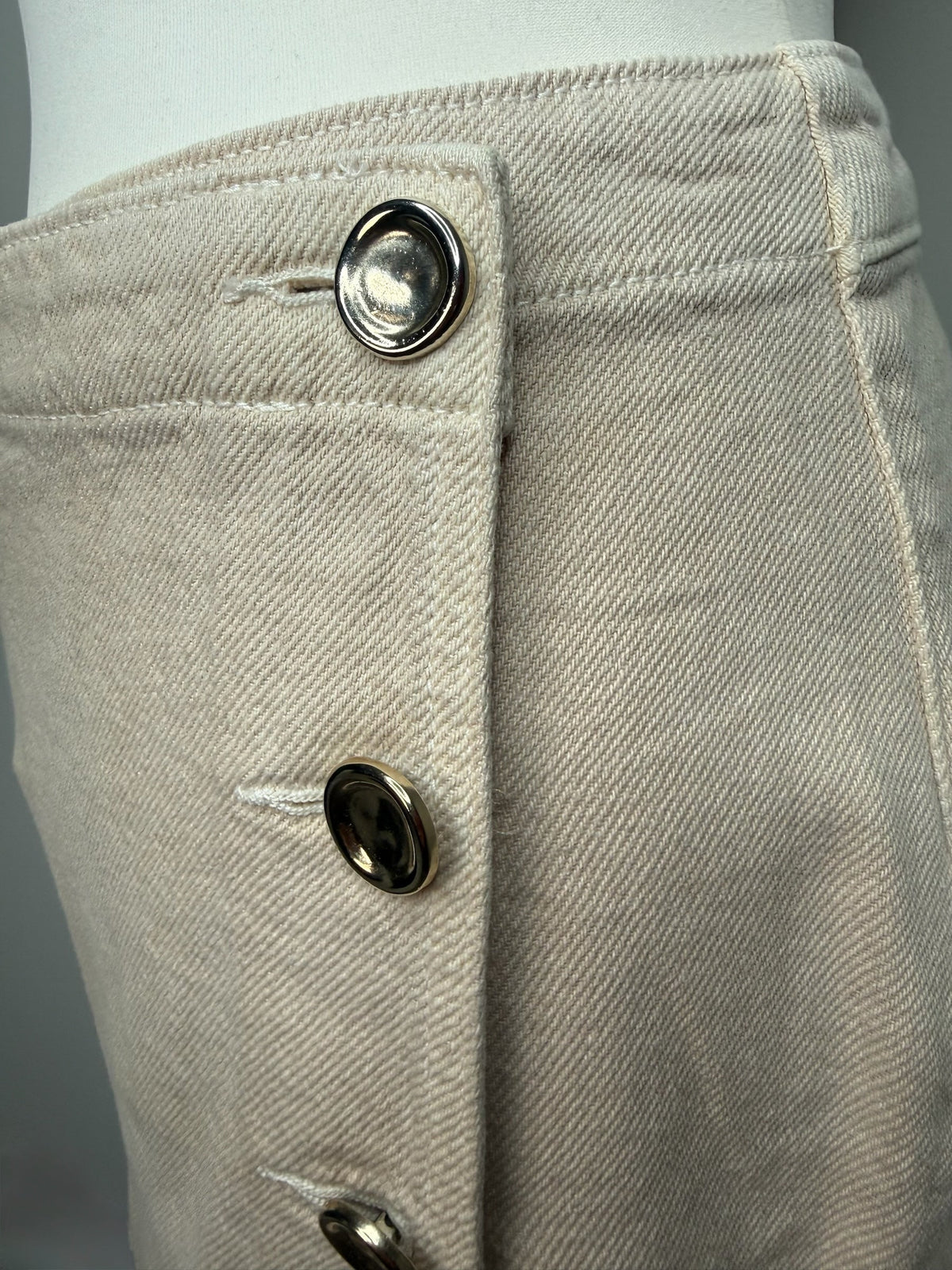 Style Reset beige cotton denim mini skirt featuring a side button-down detail with polished metallic buttons.