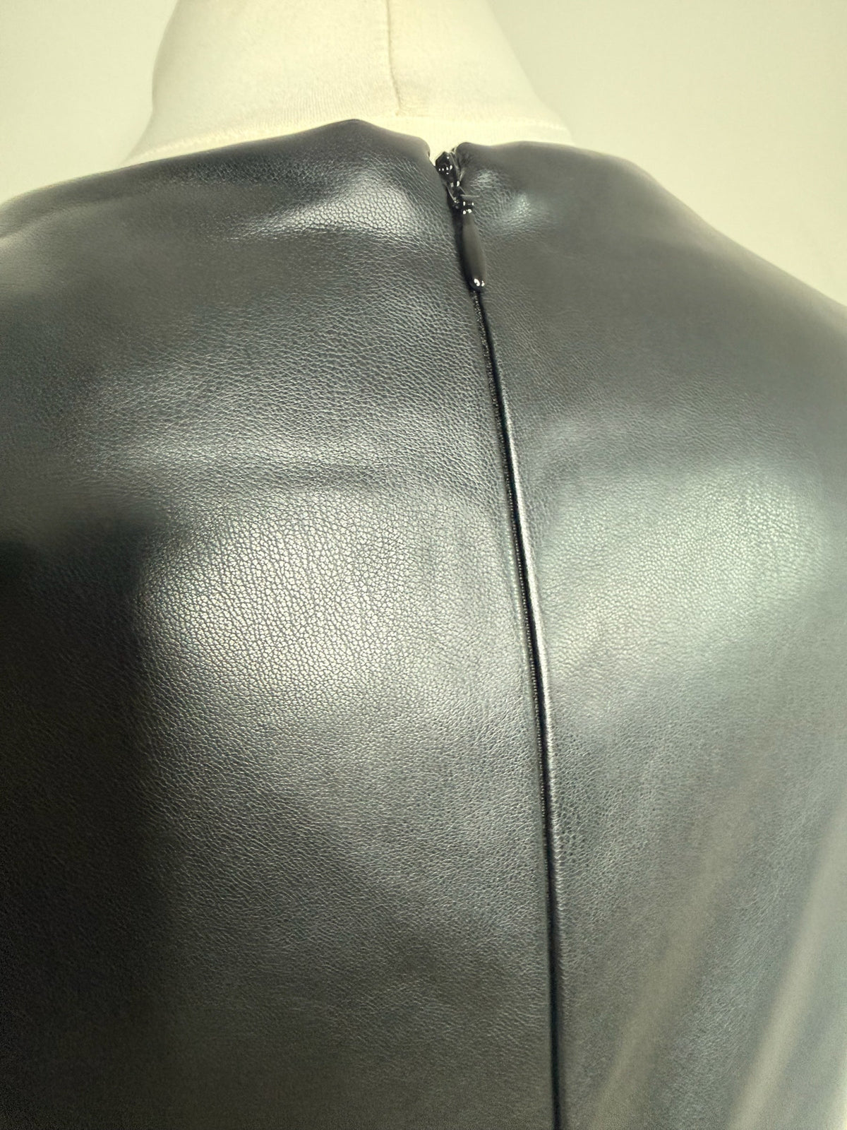 Style Reset black faux leather midi dress back view showing the discreet zip fastening and textured material.