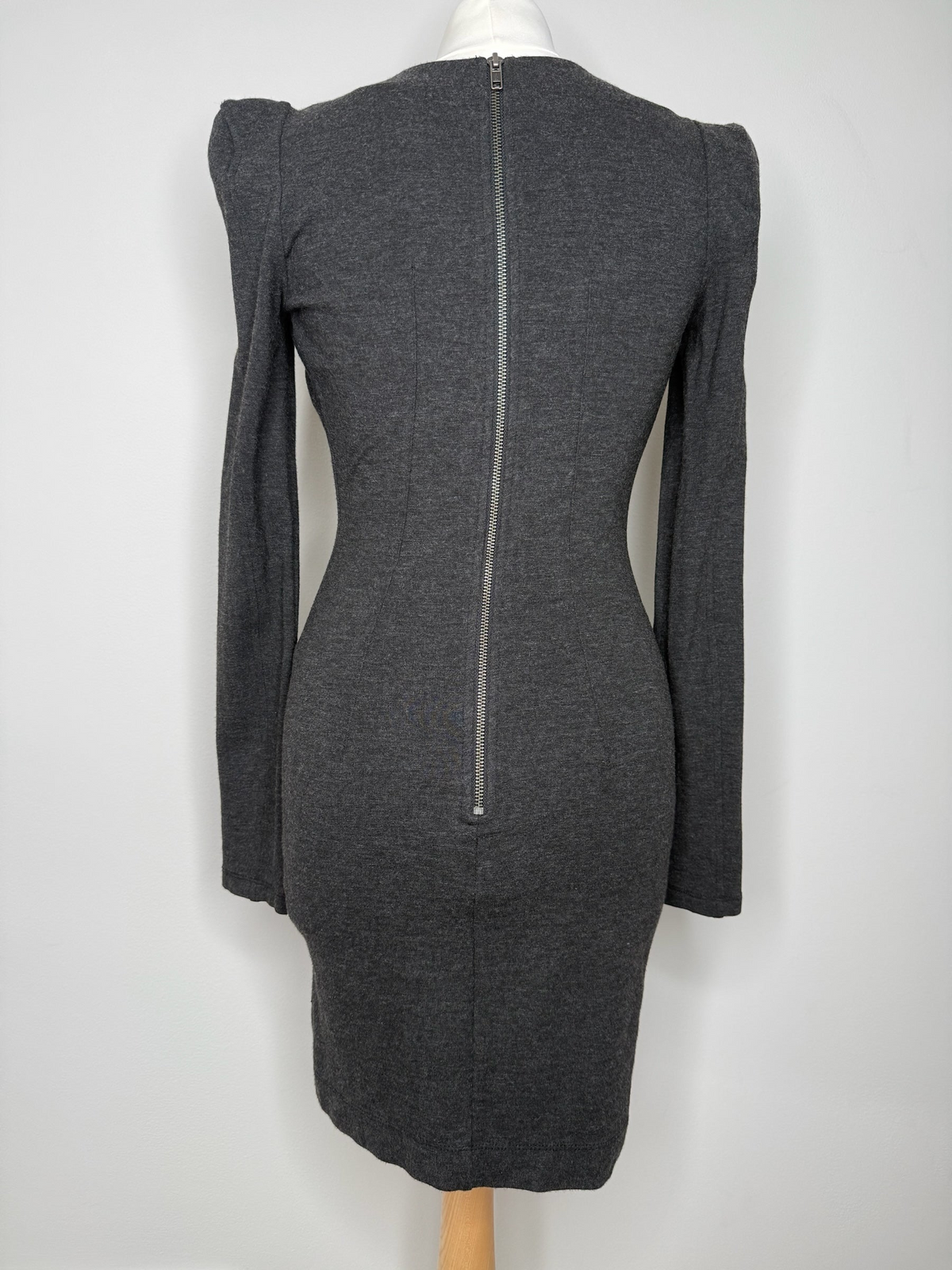 Style Reset charcoal grey long sleeve wrap dress with puff shoulders and a full-length exposed back zip closure.