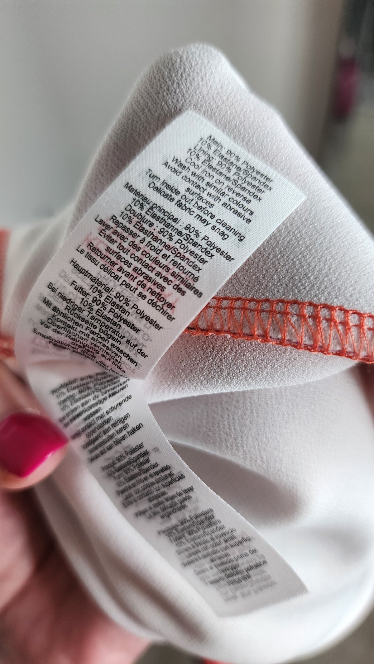 Style Reset dress care label showing 90 percent polyester and 10 percent elastane composition in multiple languages