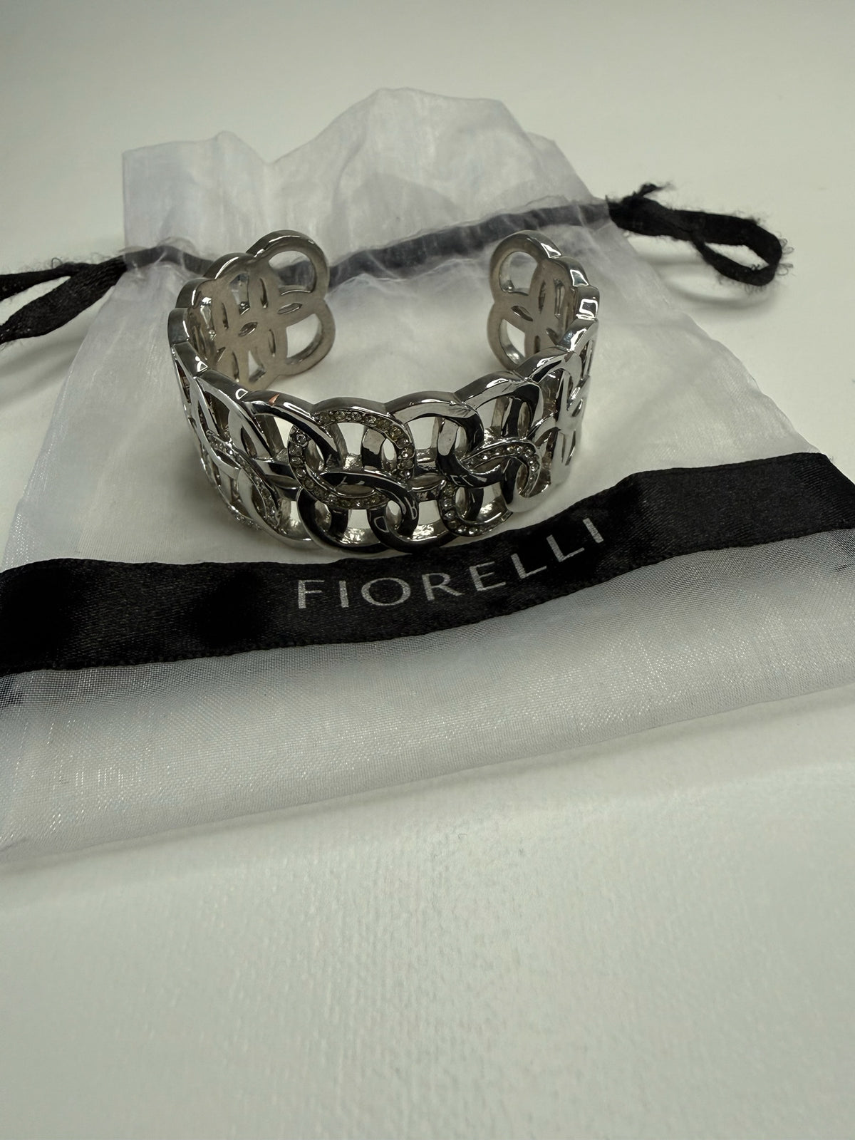 Style Reset FIORELLI silver-tone wide cuff bracelet with interlocking circular links and crystal accents in a pouch