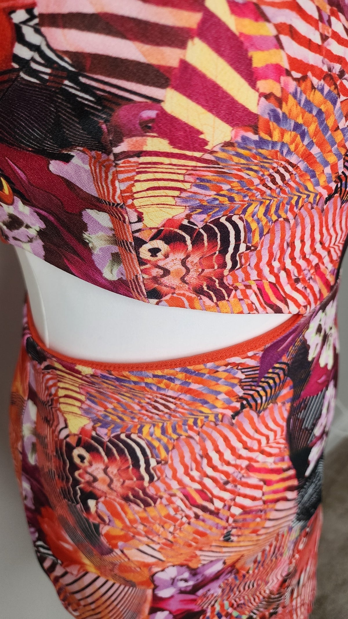 Style Reset sleeveless mini dress featuring a vibrant orange, pink, and purple abstract floral print with waist cut-out