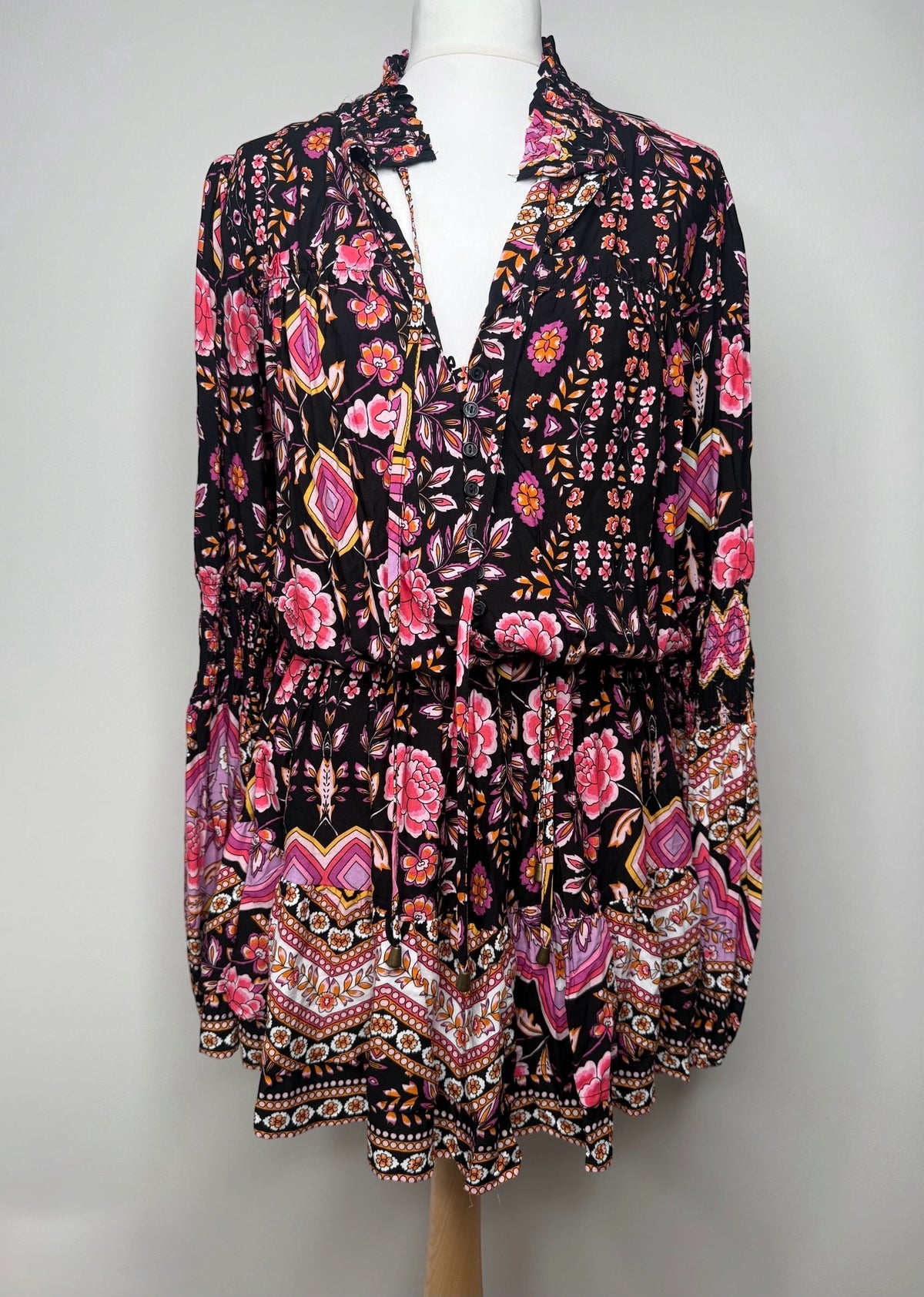 Style Reset bohemian mini dress in black with a vibrant multi-coloured floral print, V-neck, and ruffled collar.