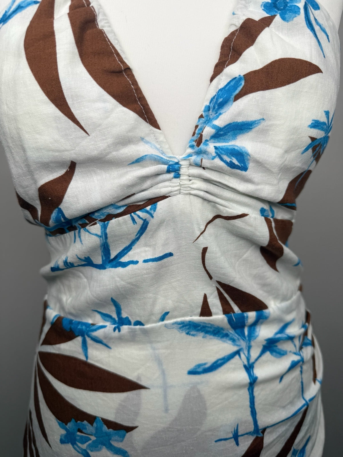 Style Reset white mini dress with blue and brown tropical floral print, featuring a gathered halter-neck bust.