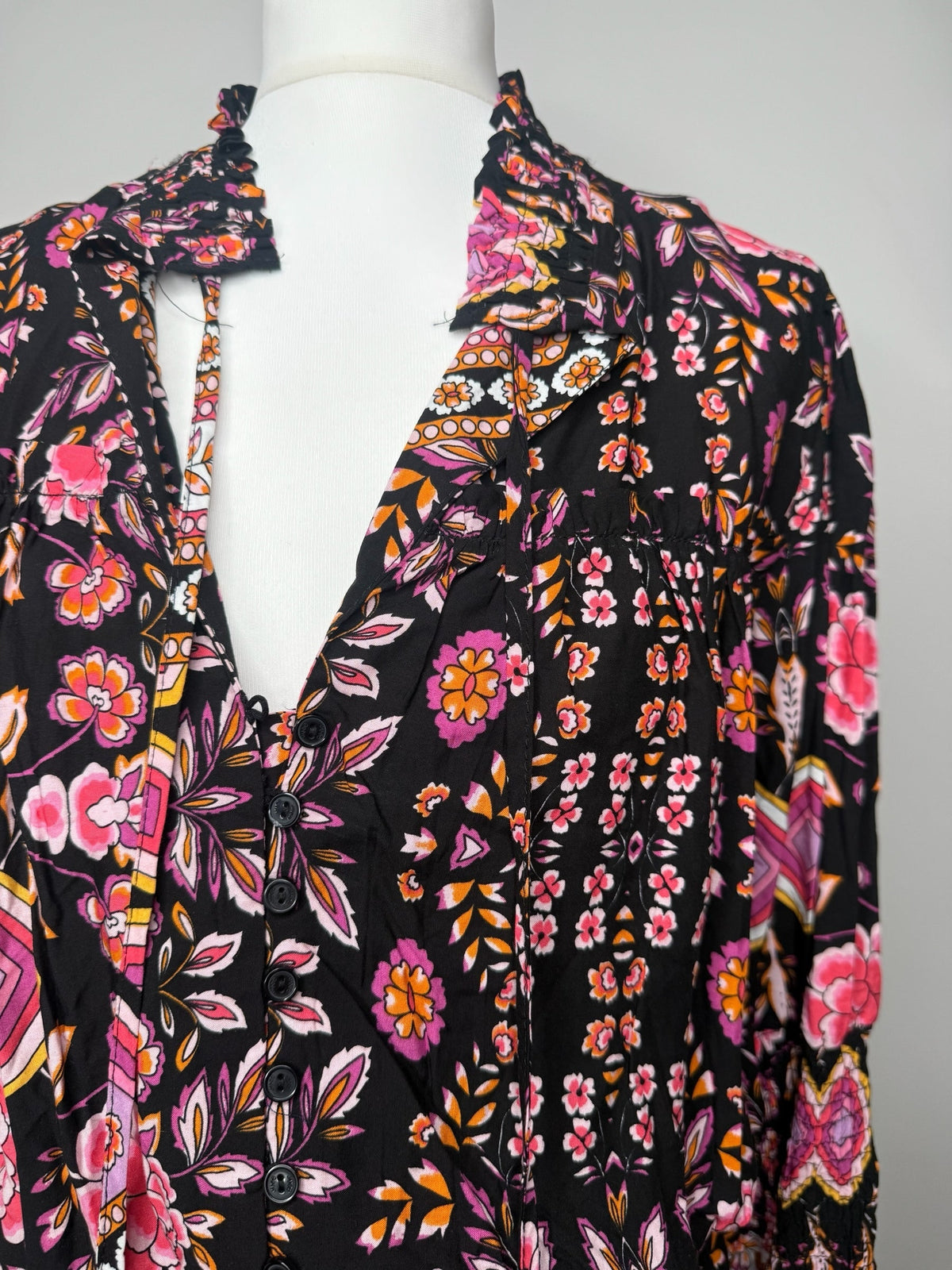 Style Reset floral print mini dress with a V-neckline, button detailing, and ruffled collar on a black base.