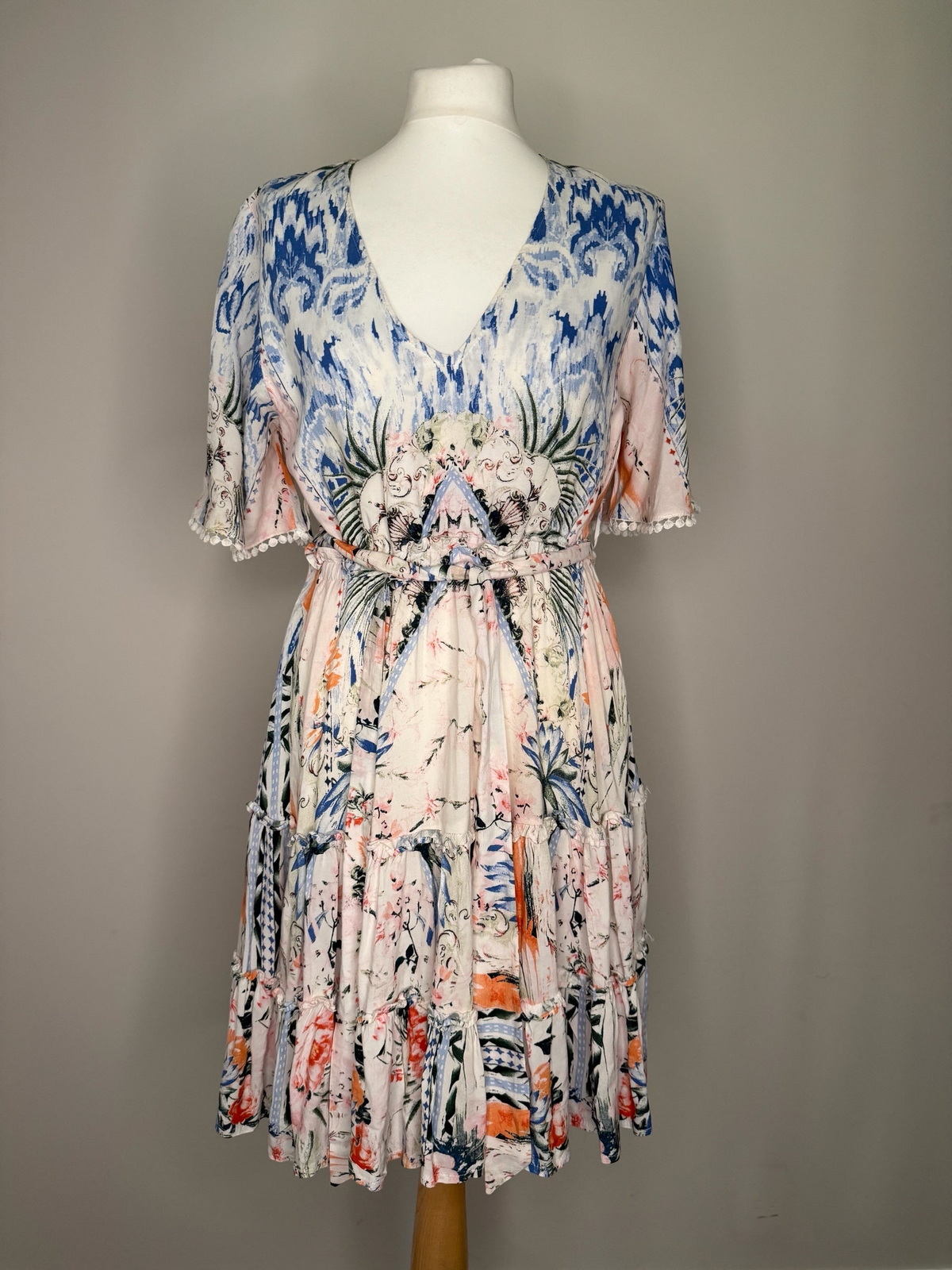 Style Reset JANE midi dress featuring a pastel pink, blue, and green botanical print with a V-neck and pom-pom sleeves.