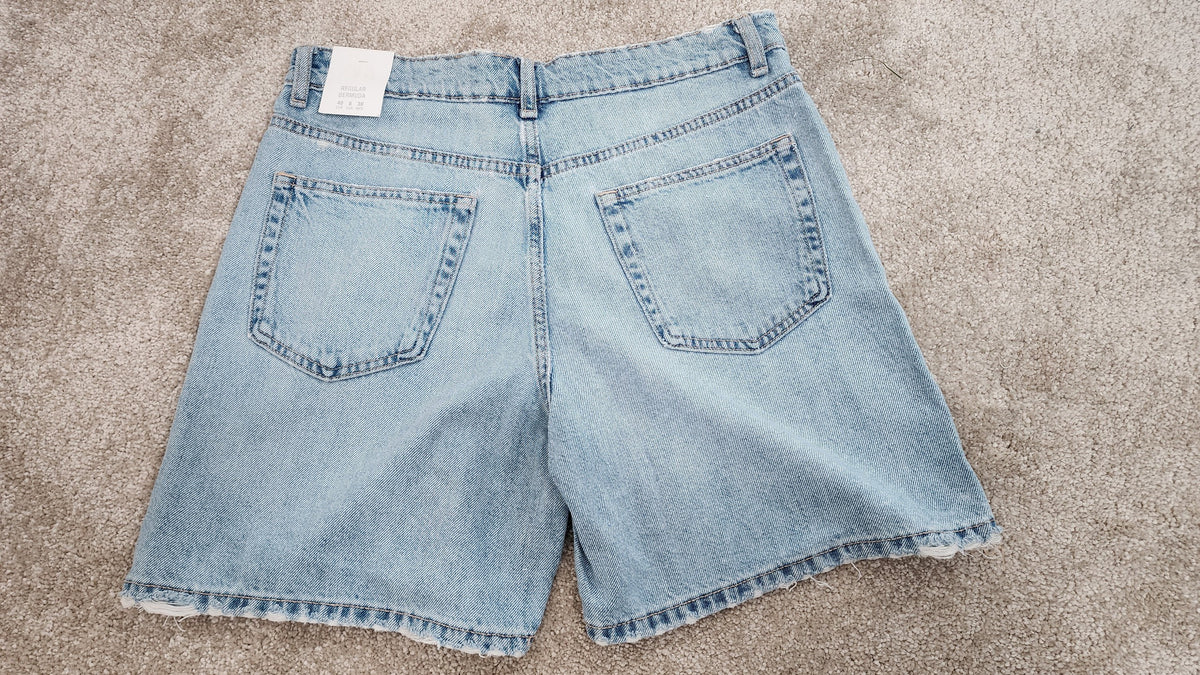 Style Reset light wash denim Bermuda shorts with a high rise waist, raw hem finish, and classic five-pocket design.