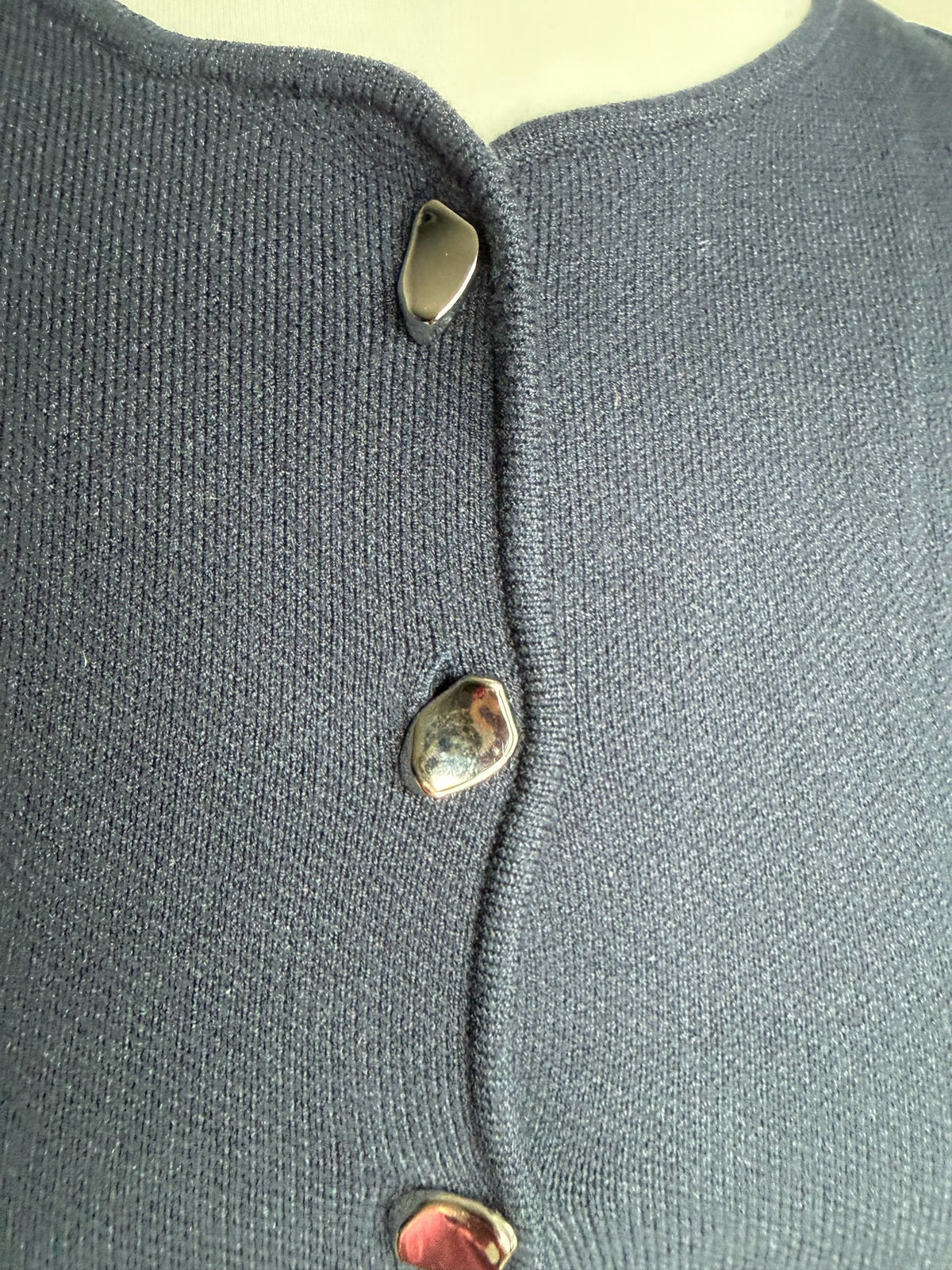 Style Reset navy blue sleeveless knit top featuring metallic button-down detail and structured fabric texture.