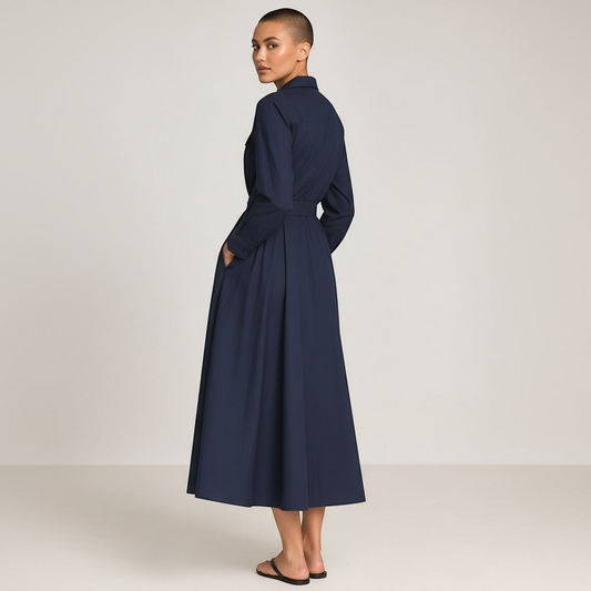 Style Reset navy midi shirt dress with long sleeves, waist tie, and side pockets worn by a model, back view.