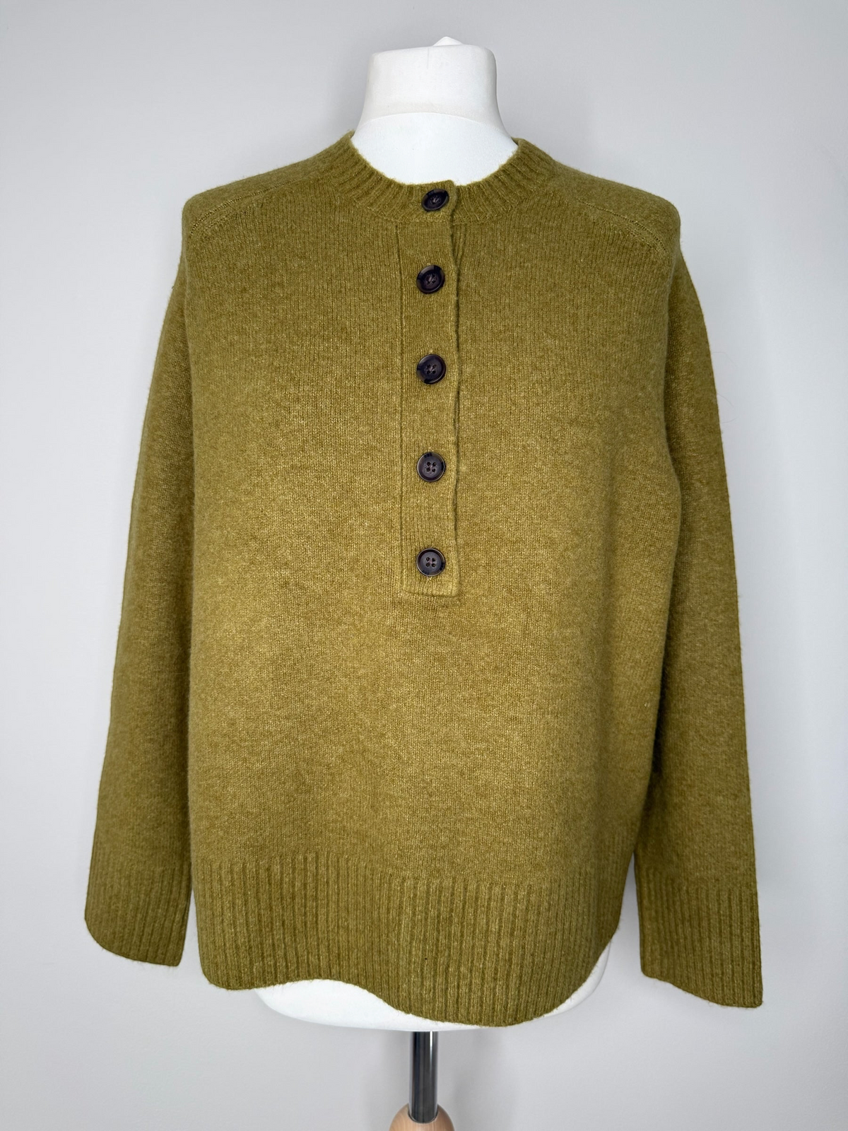 Style Reset olive green knit jumper with a crew neckline and button-up placket, featuring ribbed cuffs and hem.