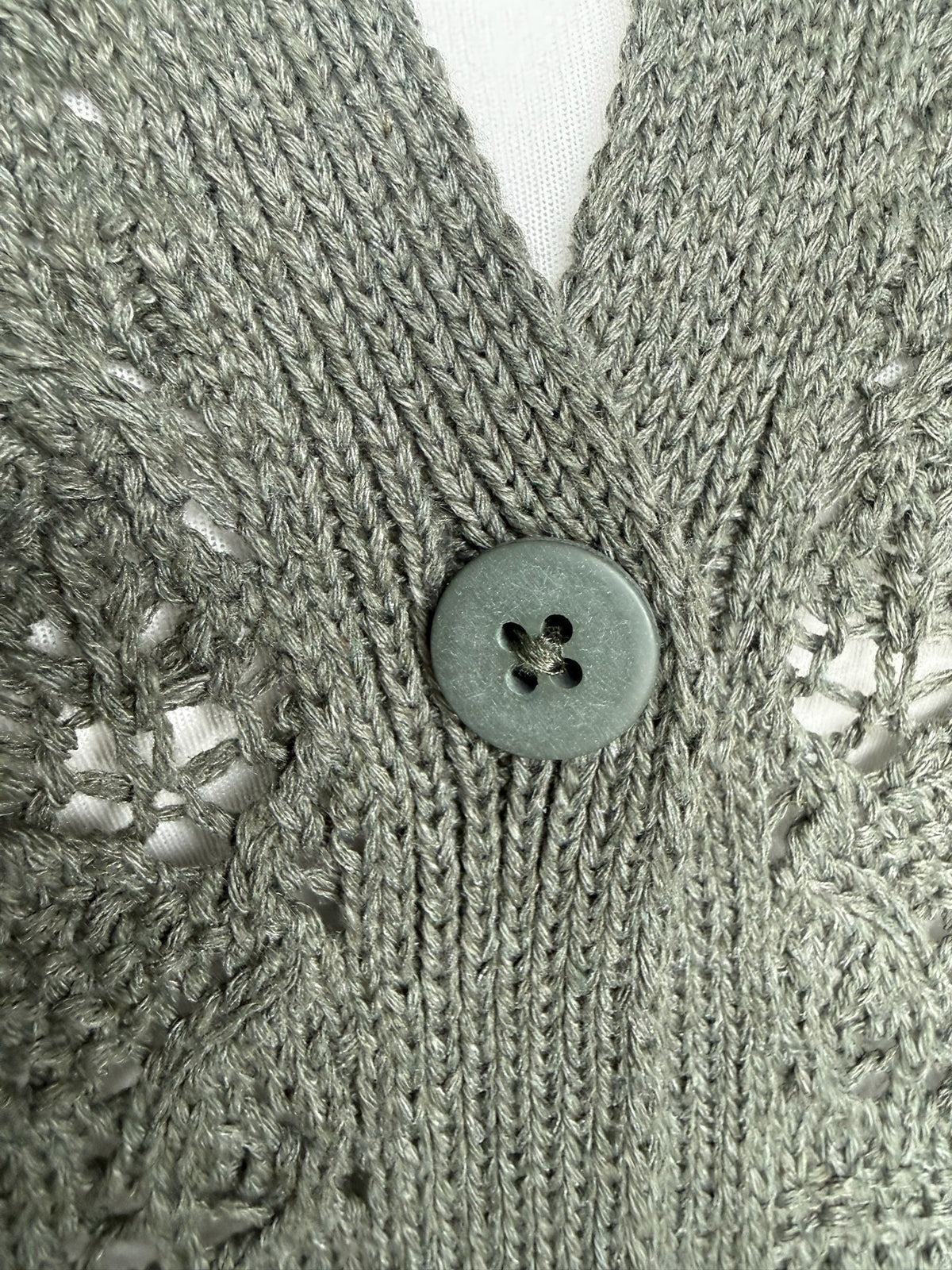 Style Reset olive green open knit cardigan featuring intricate crochet style openwork and a matching button detail