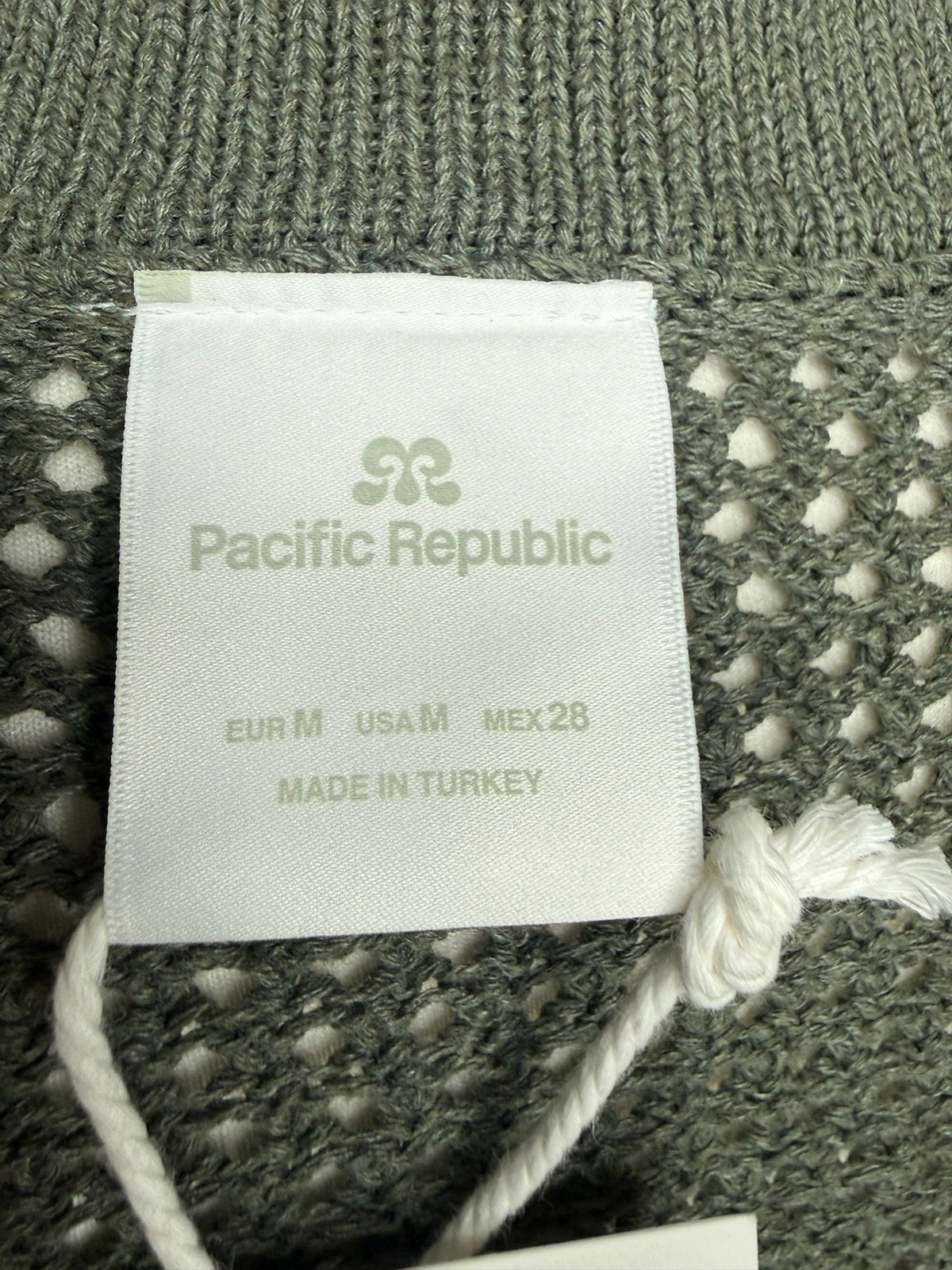 Style Reset Pacific Republic olive green open knit cardigan garment label showing size M and made in Turkey details