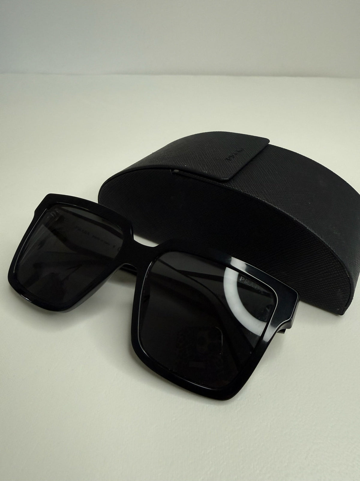 Style Reset Prada black oversized square frame sunglasses with matching Saffiano-textured protective case