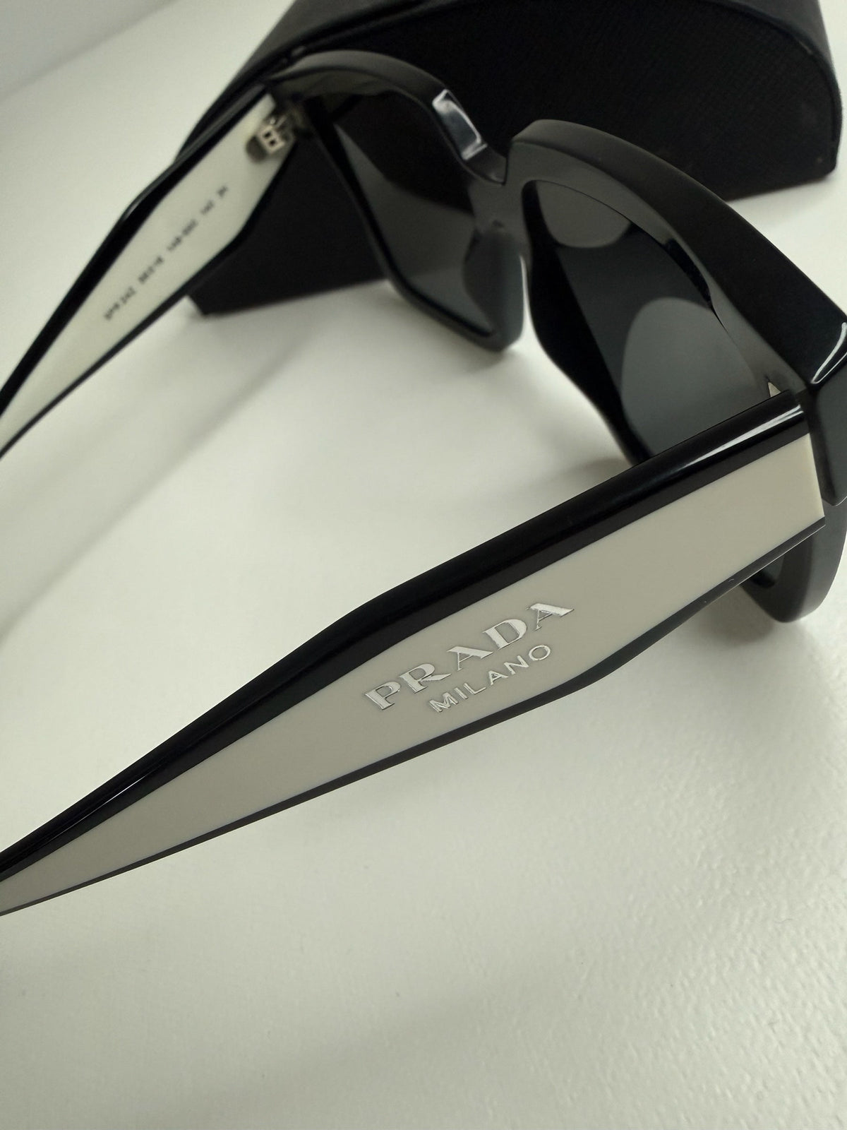 Style Reset Prada square frame sunglasses in black acetate with white temple logo detail and protective case.