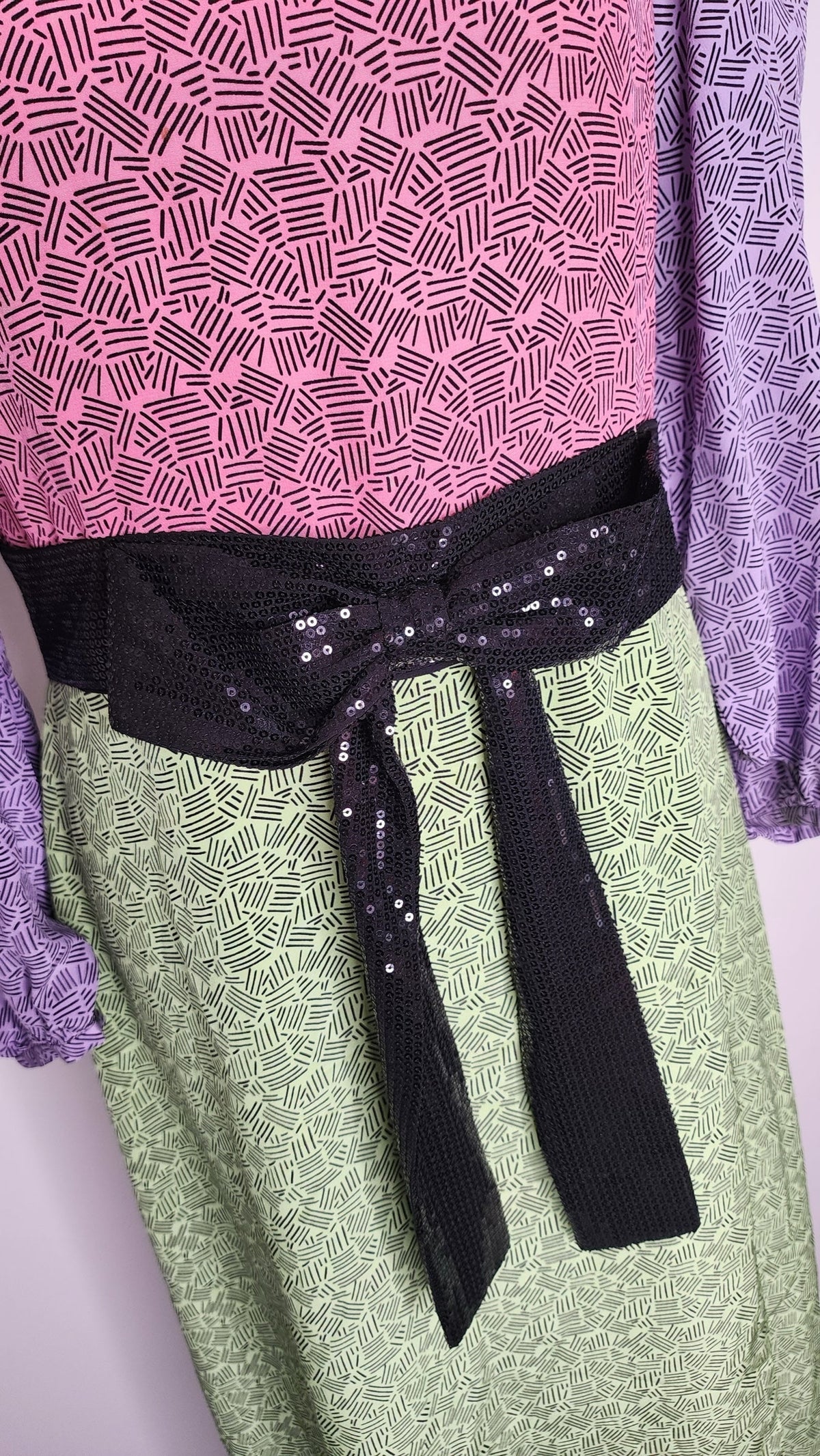 Style Reset Olivia Rubin silk midi dress in pink, lime, and purple with a geometric print and black sequin waist belt.